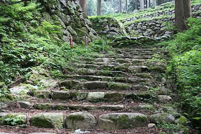 石段となっている古道の向こうにも石垣が