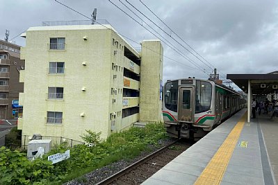 ホームに停車するE721系電車
