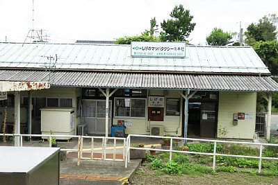 ホームから見た駅舎の屋根に看板が