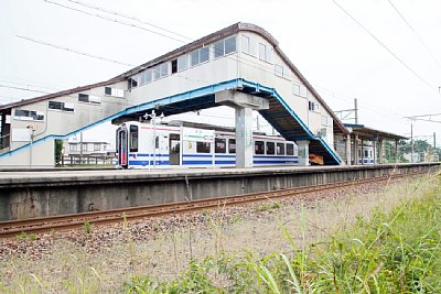 跨線橋の下にHK100型電車が)