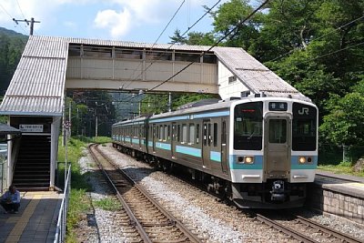 相対式ホームと跨線橋と211系電車